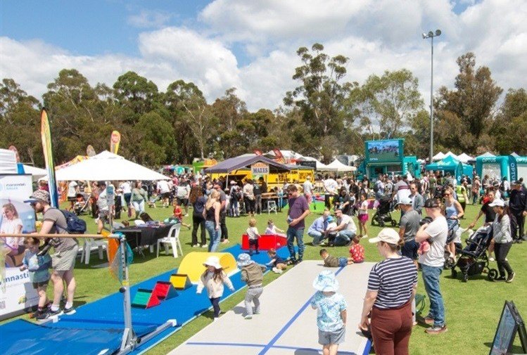 Families and stallholders at the Maroondah Festival on a sunny day in the park